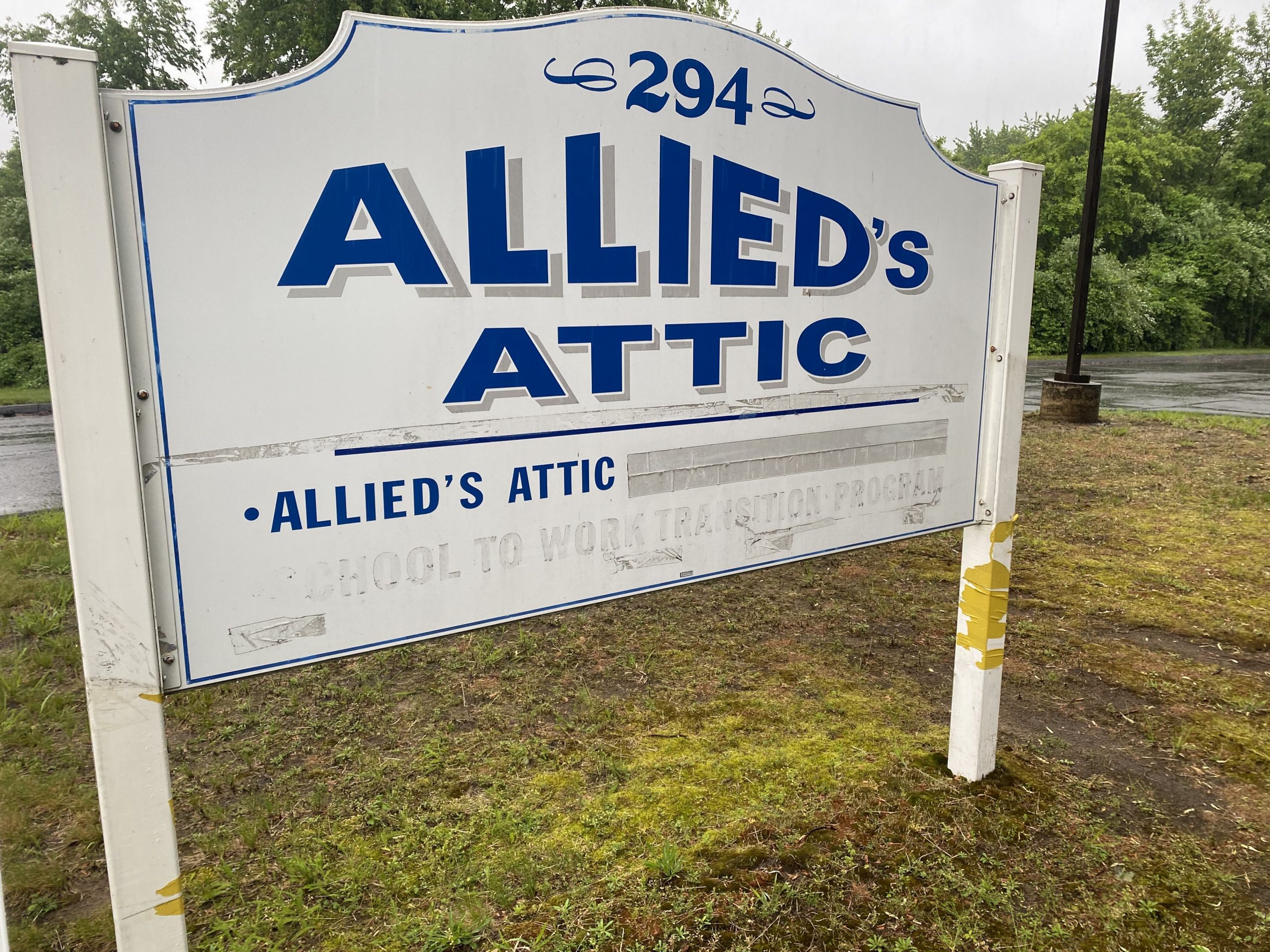 Photo of Allied's Attic post and panel sign before fixing